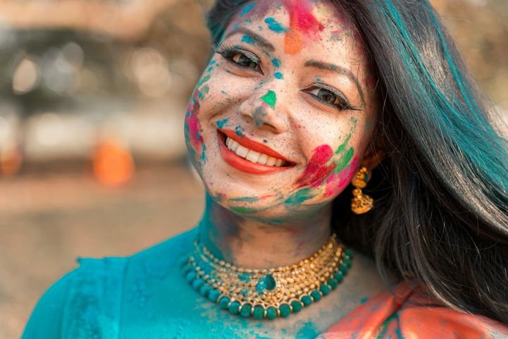 A young woman exuding true flourishing after a Holi celebration.