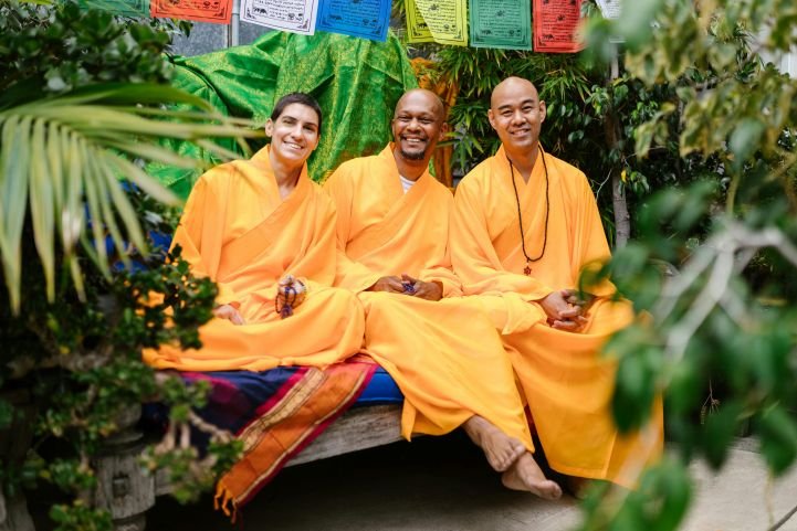 Three Buddhist monks smiling.