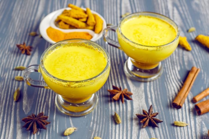 Two servings of golden milk with assorted spices.