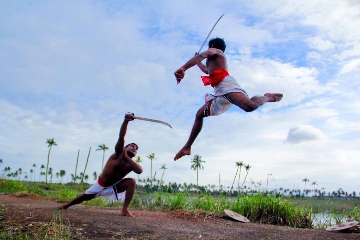Two men engaged in martial arts using swords and breathwork.