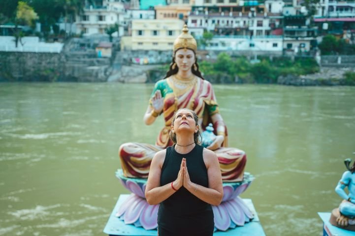 A woman standing in front of a goddess statue in India taking a deep breath.