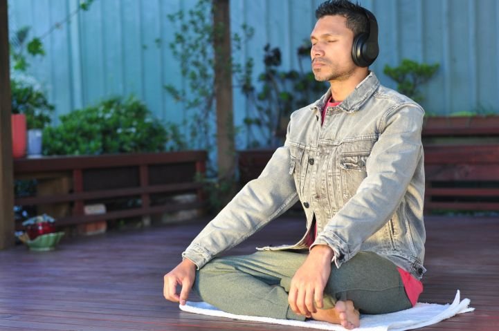 Man doing stress reduction practices with headphones.