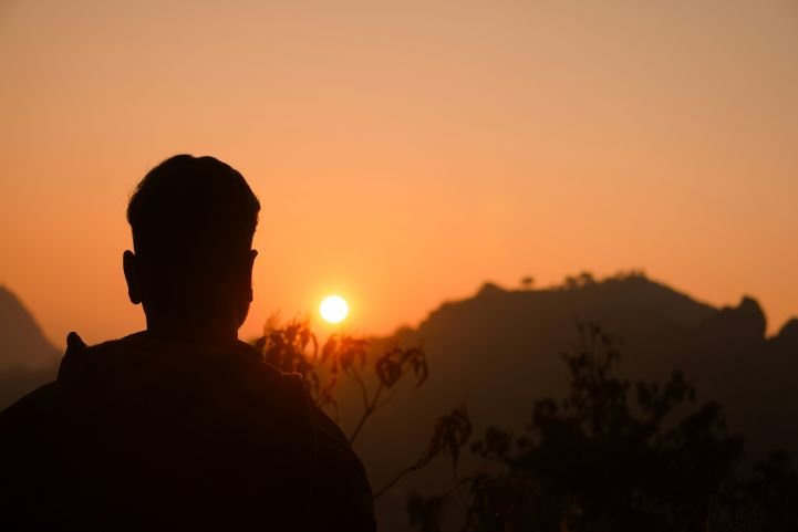A silhouette of a man at sunrise represents confidence that grows each day.