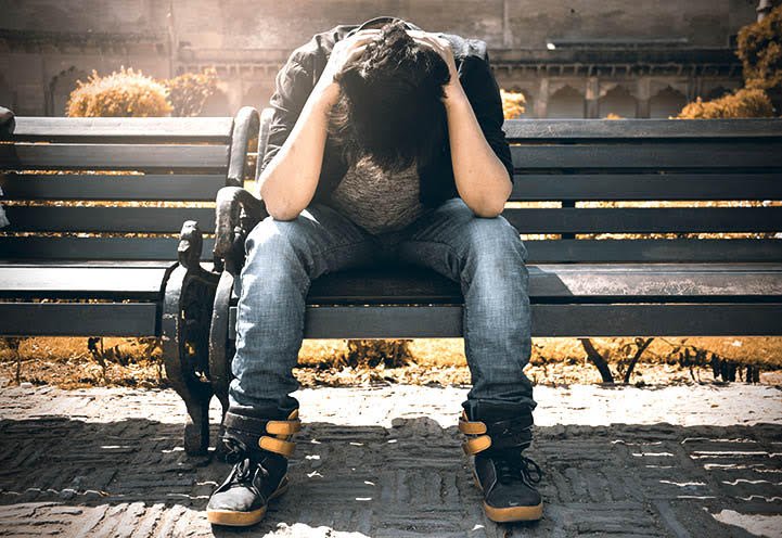 Person sitting with head in hands symbolizing how stress narrows perception and clarity.