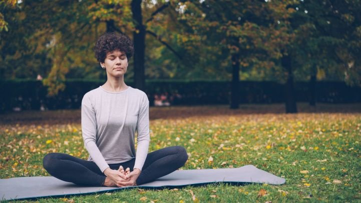Person meditating while watching clouds symbolizing witness consciousness and mindfulness.