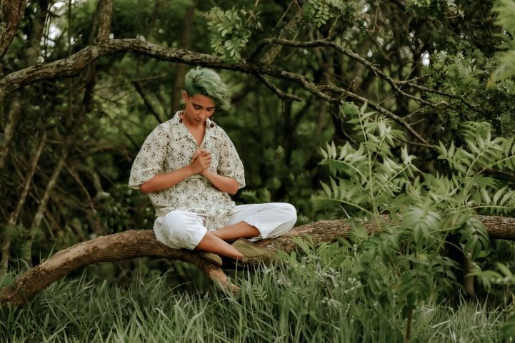 Young woman practicing breathwork while forest bathing.