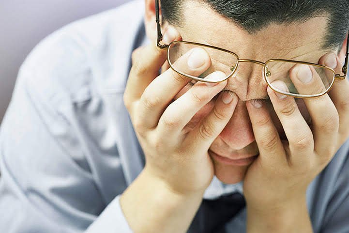 Man experiencing anxiety and fatigue after drinking the night before.