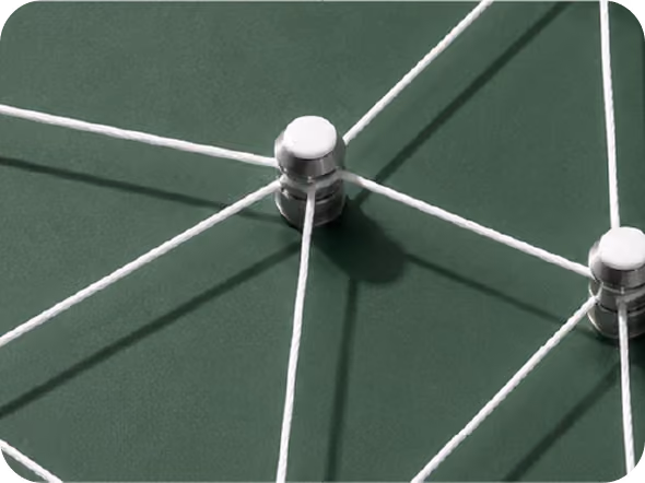 Close-up of white strings connected to silver pins on a dark green surface, forming a network.