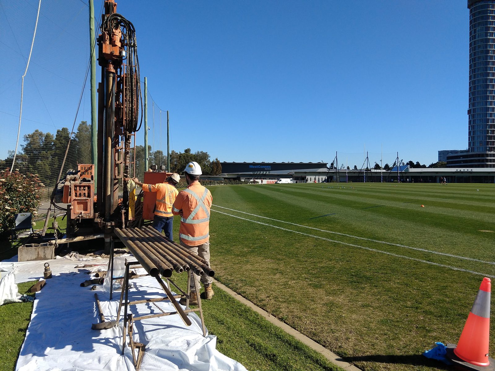 Drill rig and crew sampling beside the oval