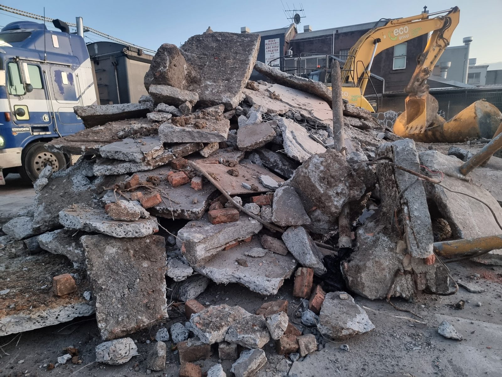 Broken concrete and an excavator during service station remediation