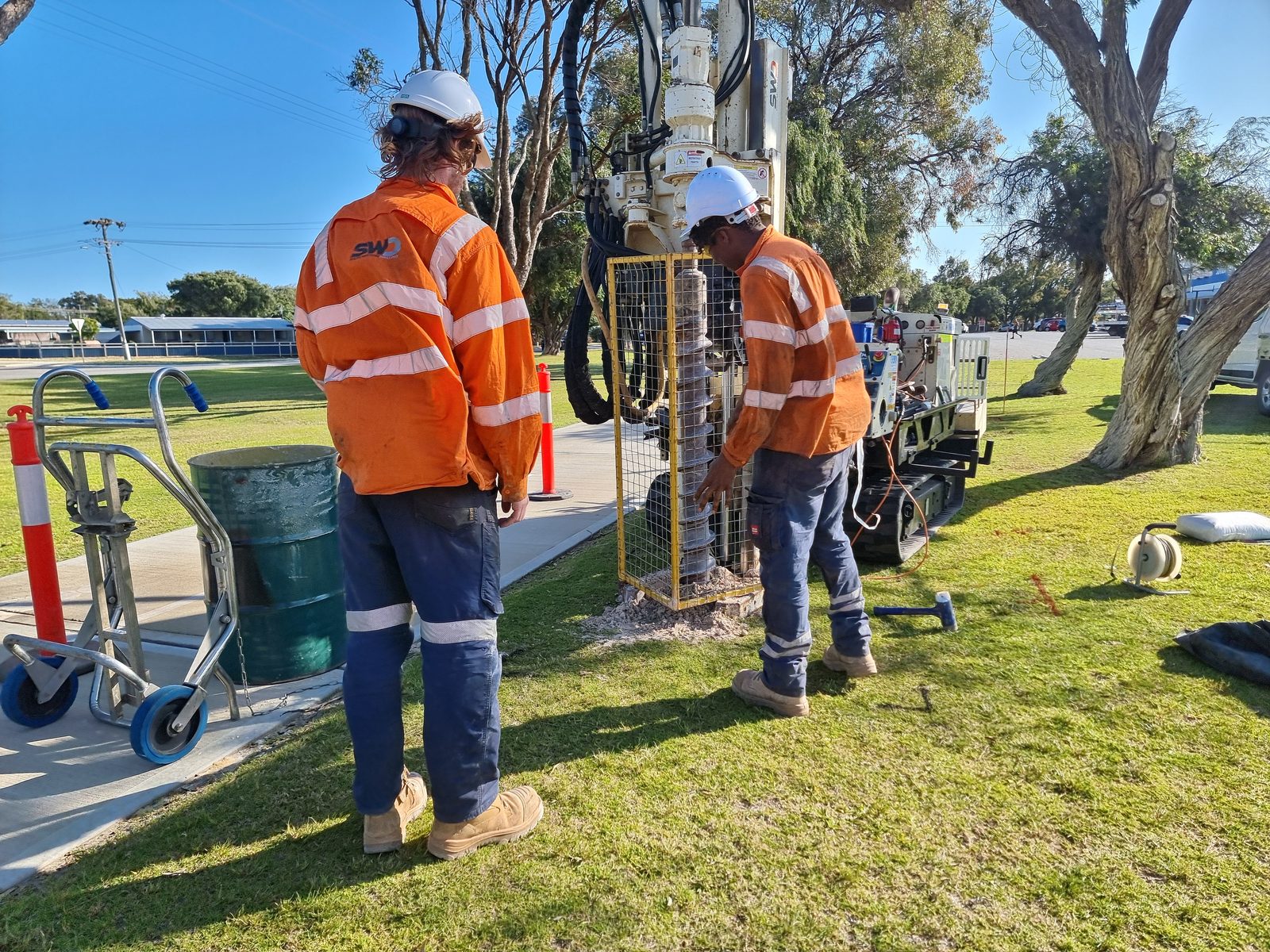 Consultants operating a drill rig on a grass verge