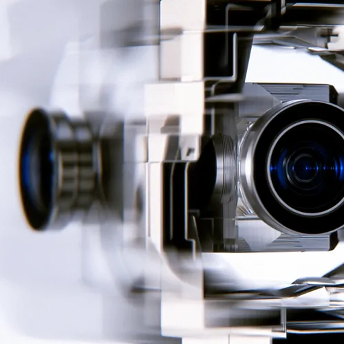 Close-up of a mechanical device with lenses and reflective surfaces, likely a camera or projector part.