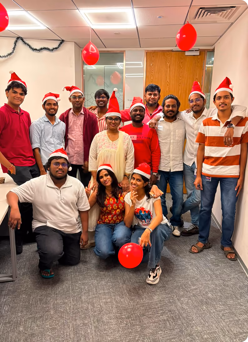Team celebrating the holidays in the office wearing Santa hats