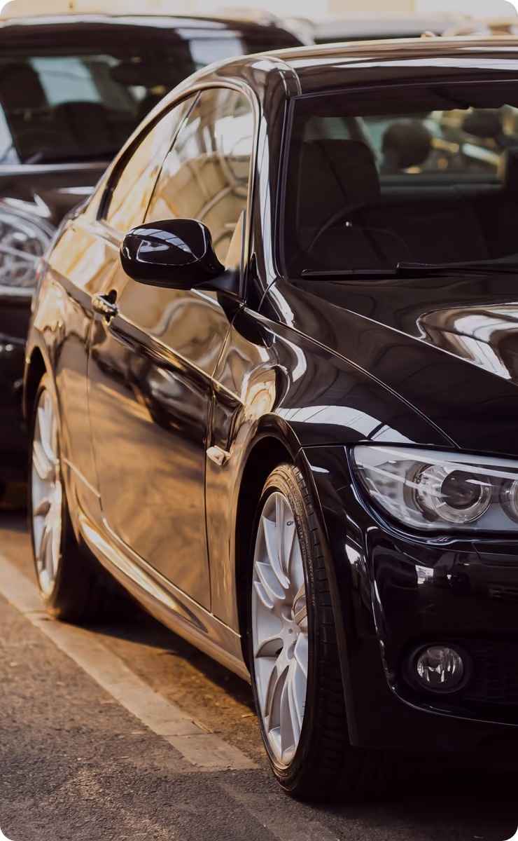 Black sedan parked outdoors, side view