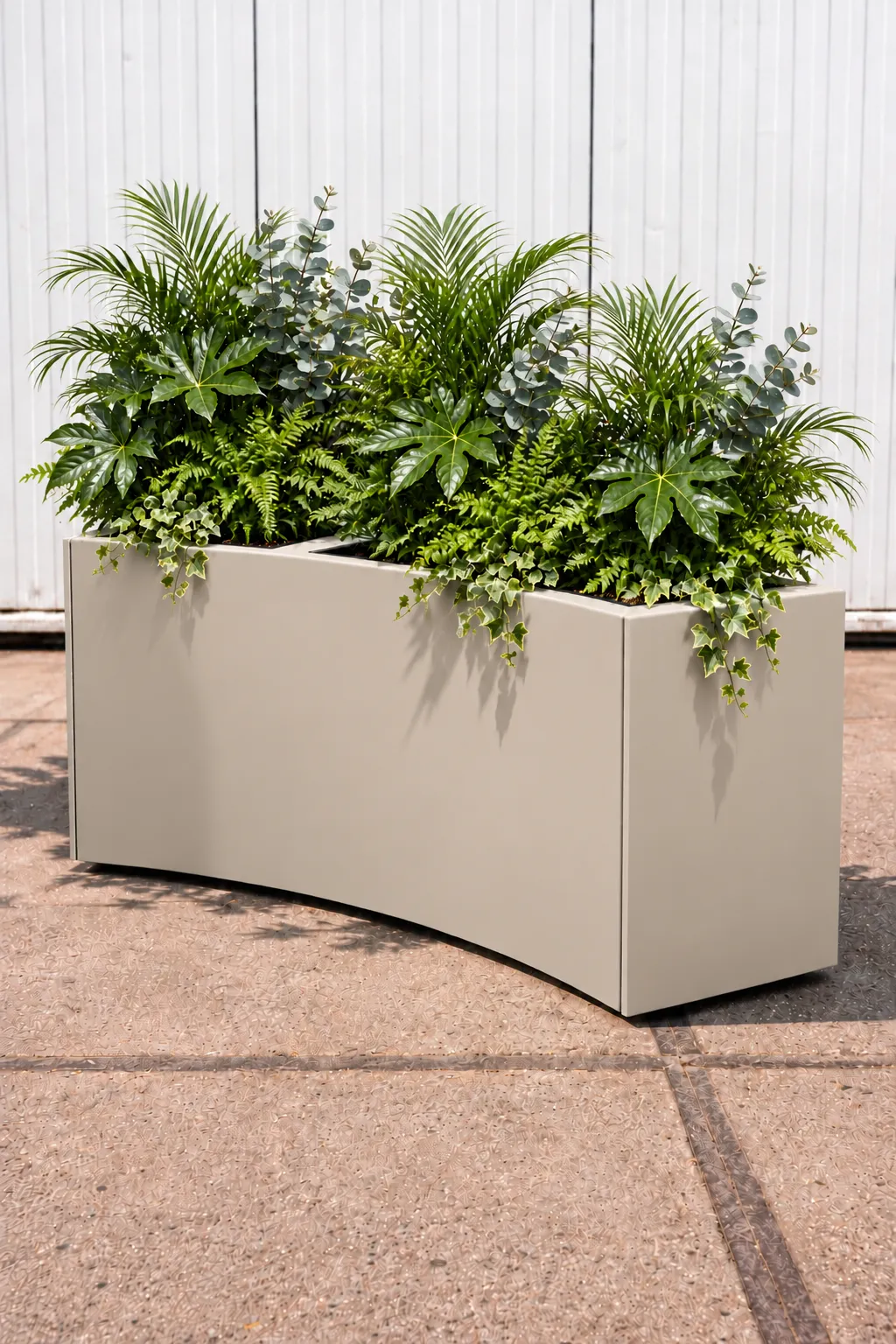 Gebogen grijze plantenbak met palmen, varens, eucalyptus en hangende klimop