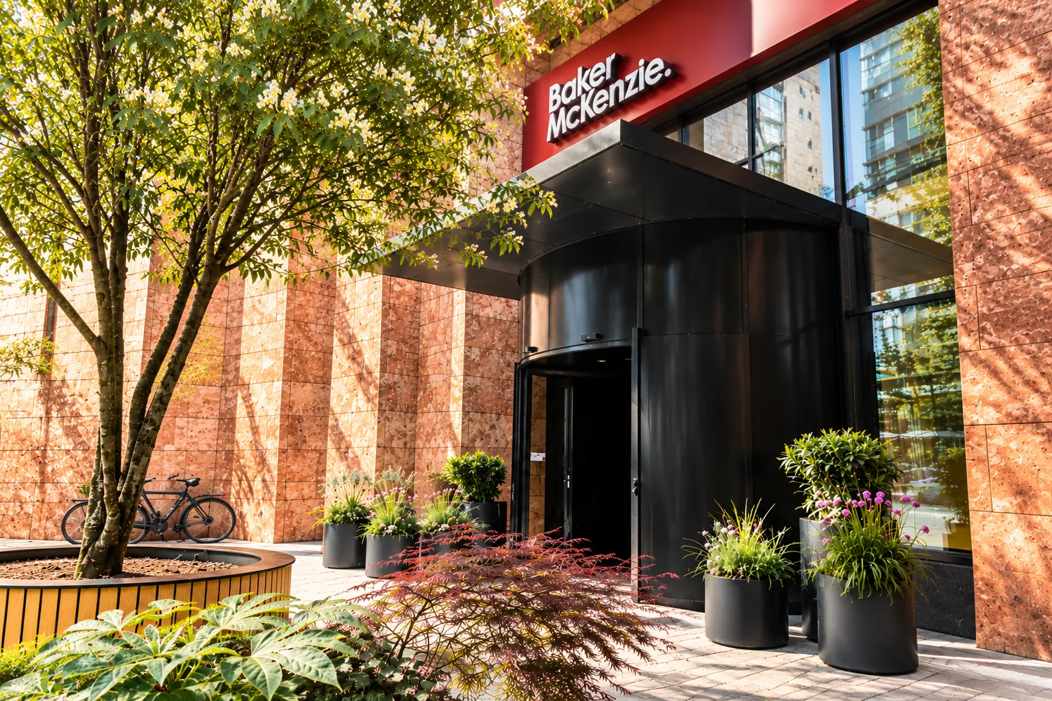 Entree van Baker McKenzie met zwarte ronde plantenbakken en groene beplanting