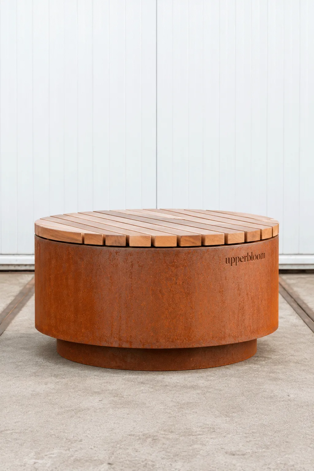 Ronde cortenstalen hocker met houten zitting als combinatie van zitplek en plantenbak