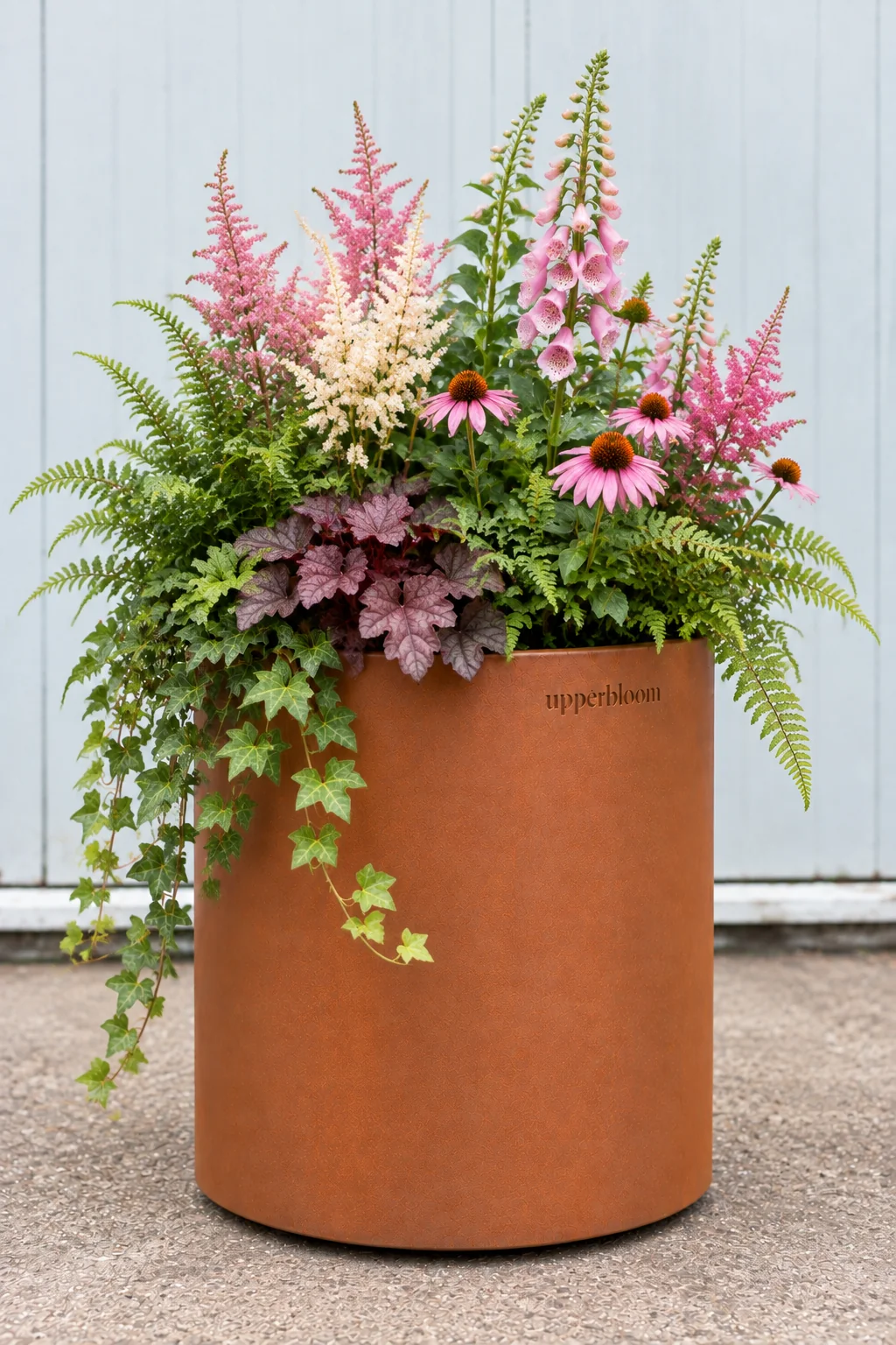 Ronde cortenstalen plantenbak met astilbe, vingerhoedskruid, echinacea, heuchera, varens en klimop