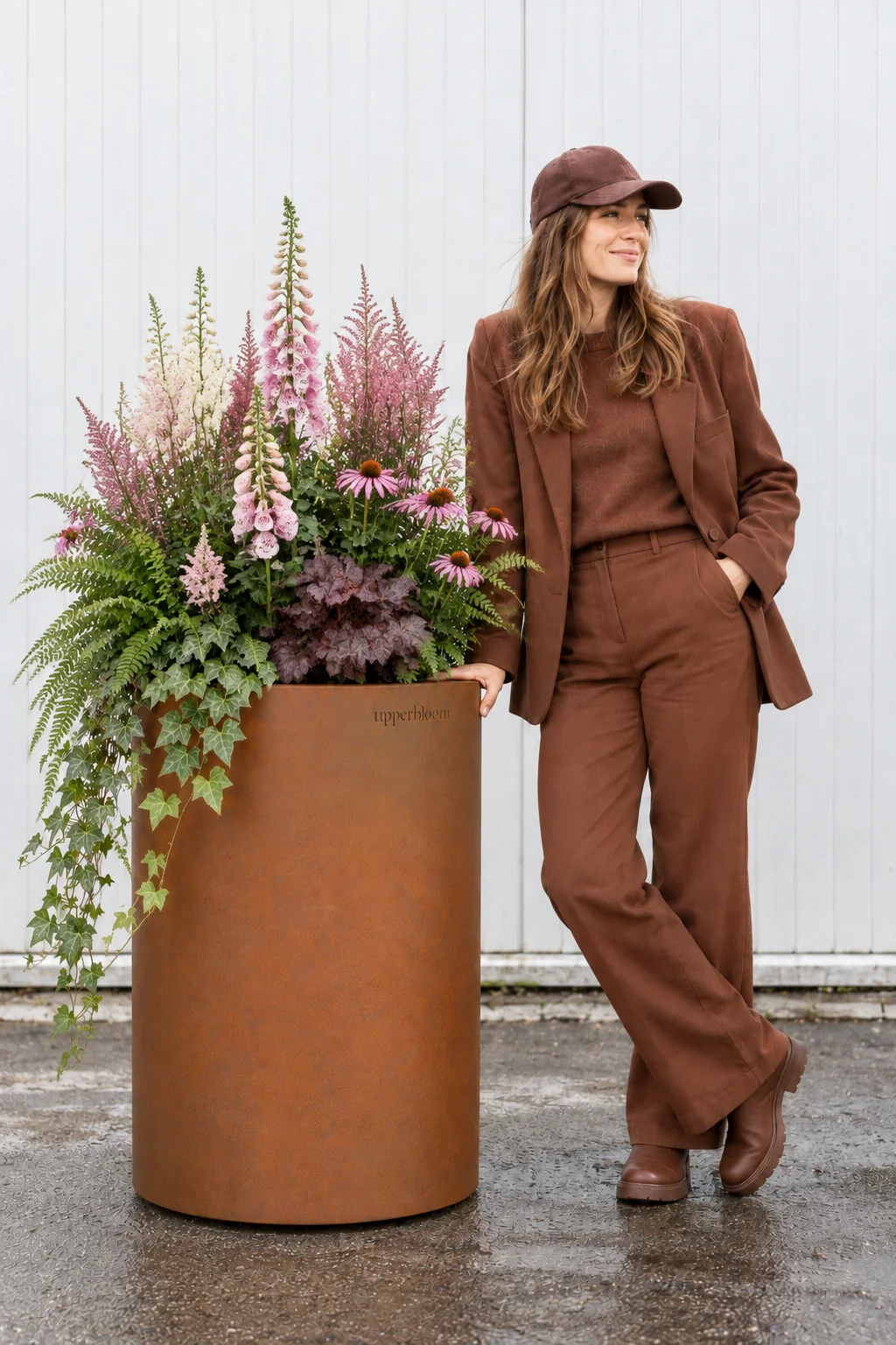 Vrouw naast hoge cortenstalen plantenbak met vingerhoedskruid, astilbe, varens en klimop