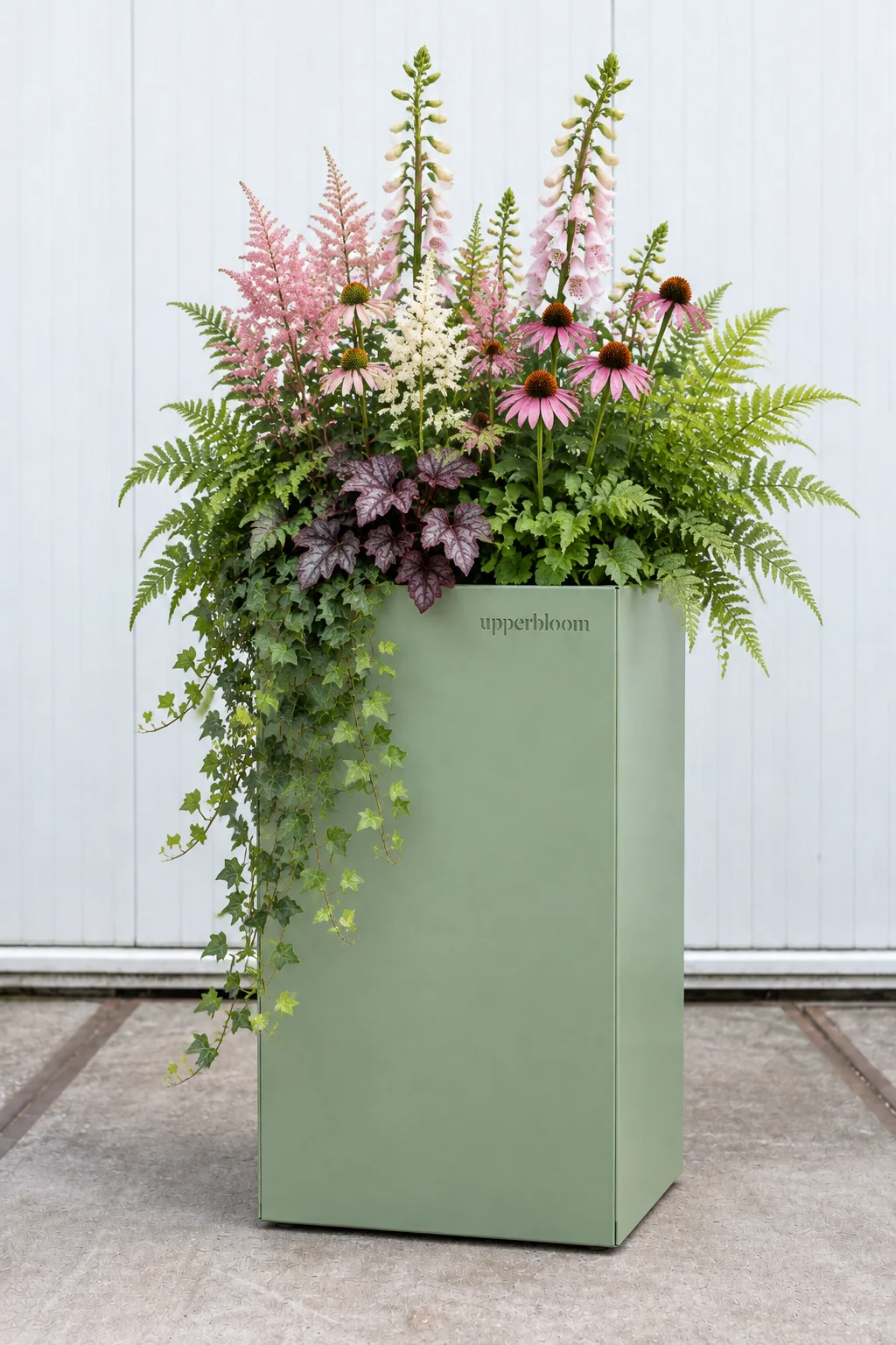 Hoge saliegroene plantenbak met astilbe, vingerhoedskruid, echinacea, varens en klimop