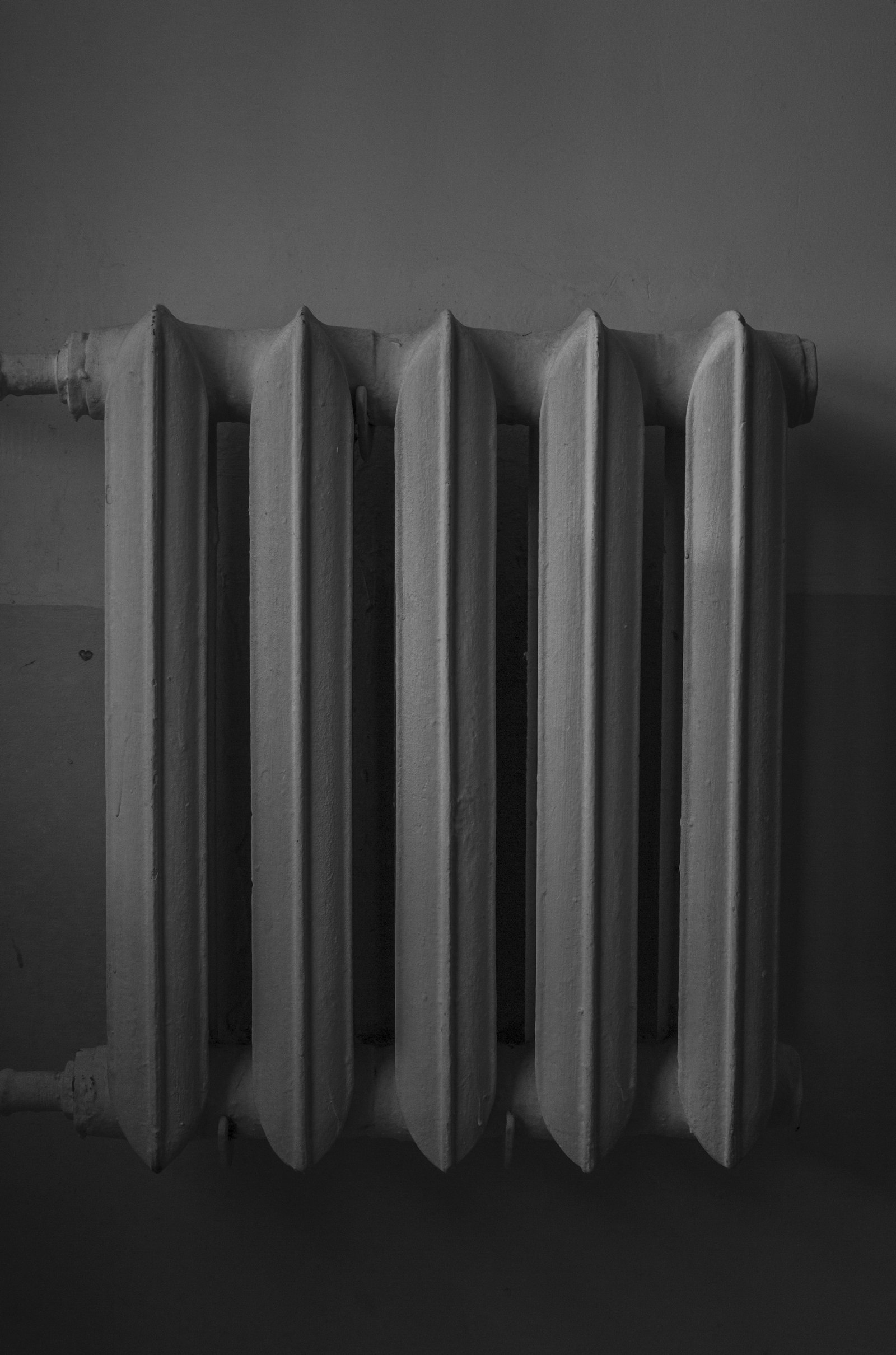 Monteur regelt een radiatorkraan waterzijdig in
