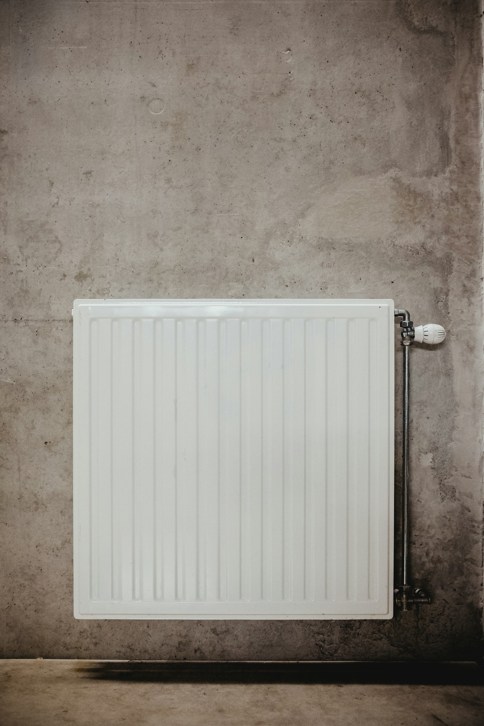 Handdoekradiator gemonteerd aan een badkamermuur