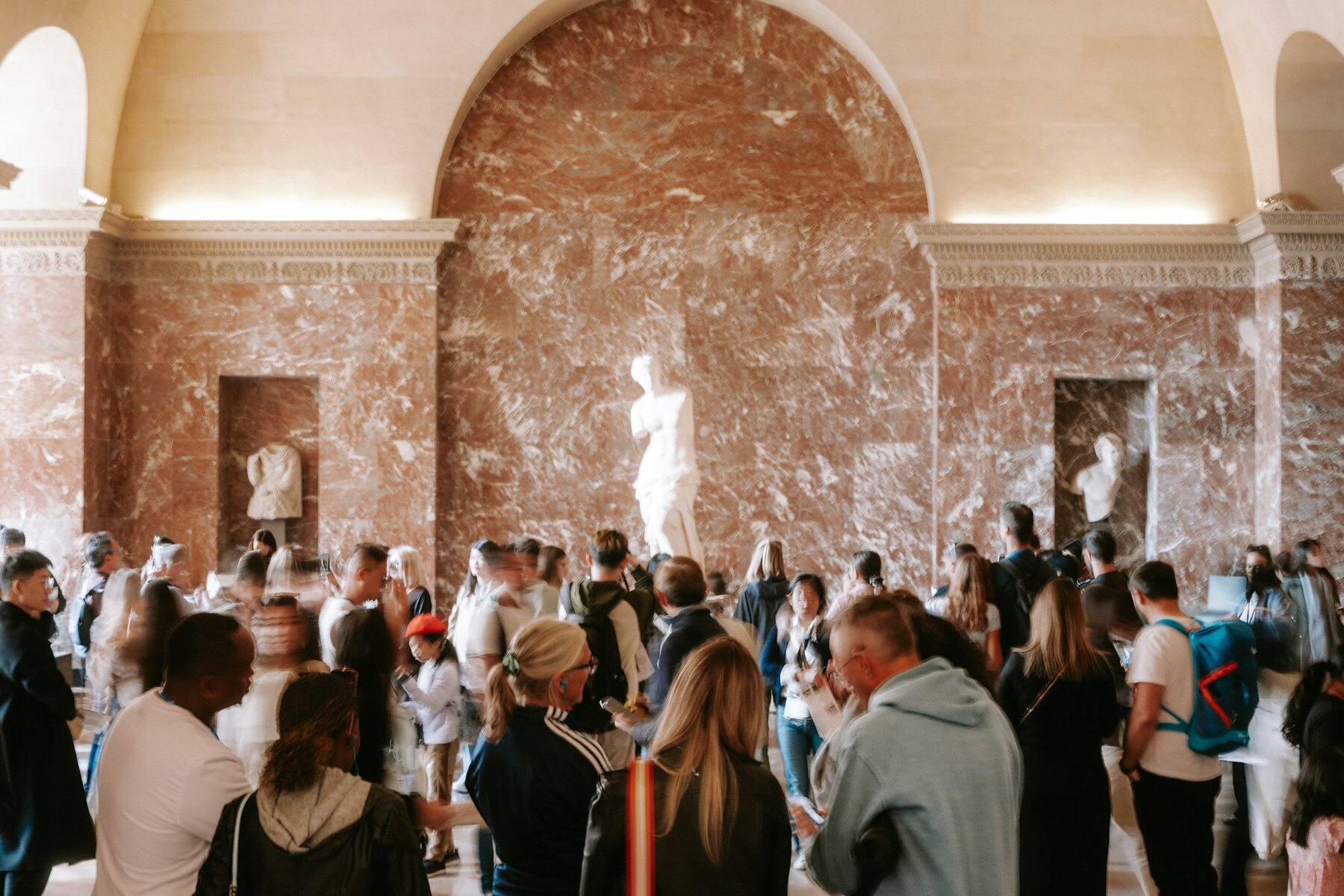 Public nombreux et diversifié dans une salle de musée