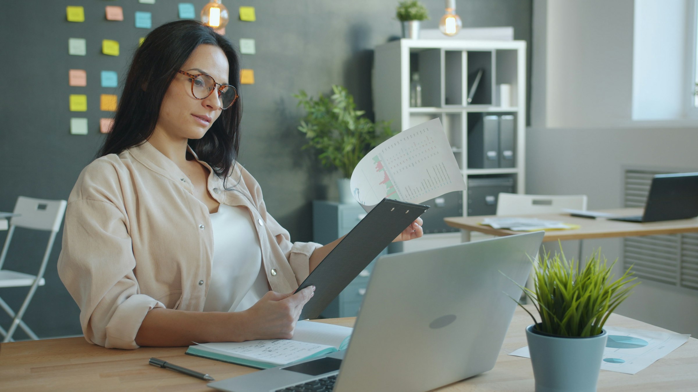 Professionnelle analysant des documents et des données pour préparer une étude