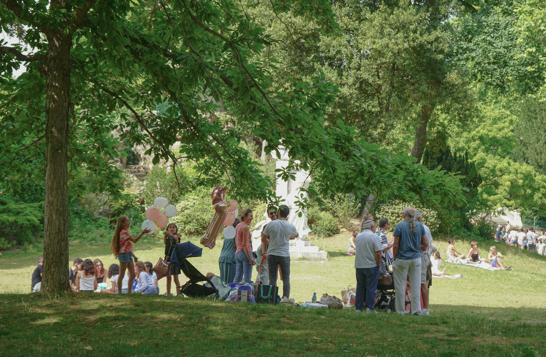 Groupe de personnes échangeant en plein air au parc Monceau à Paris.