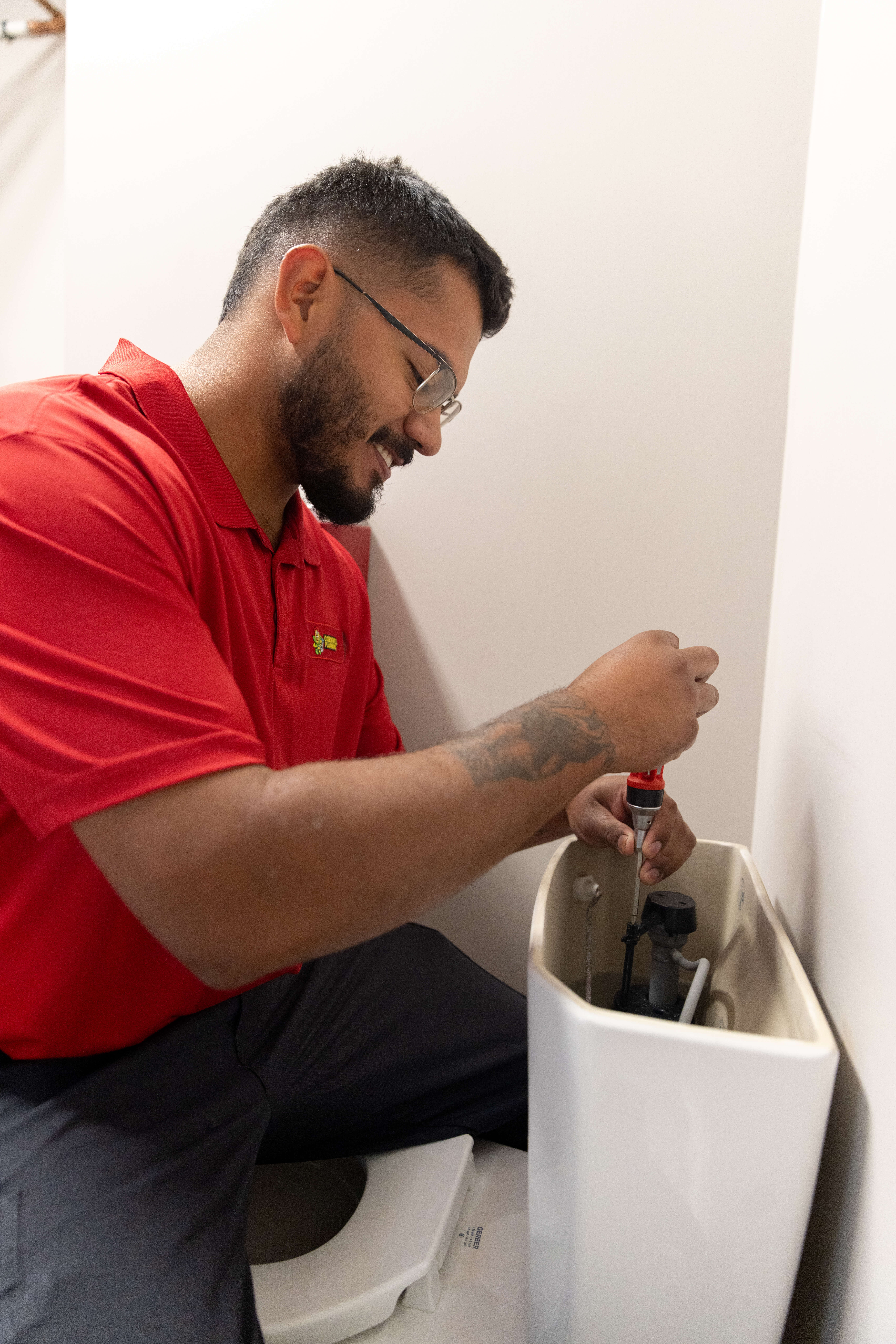 Clog removal with plunger in bathroom toilet, plumbing repair service.