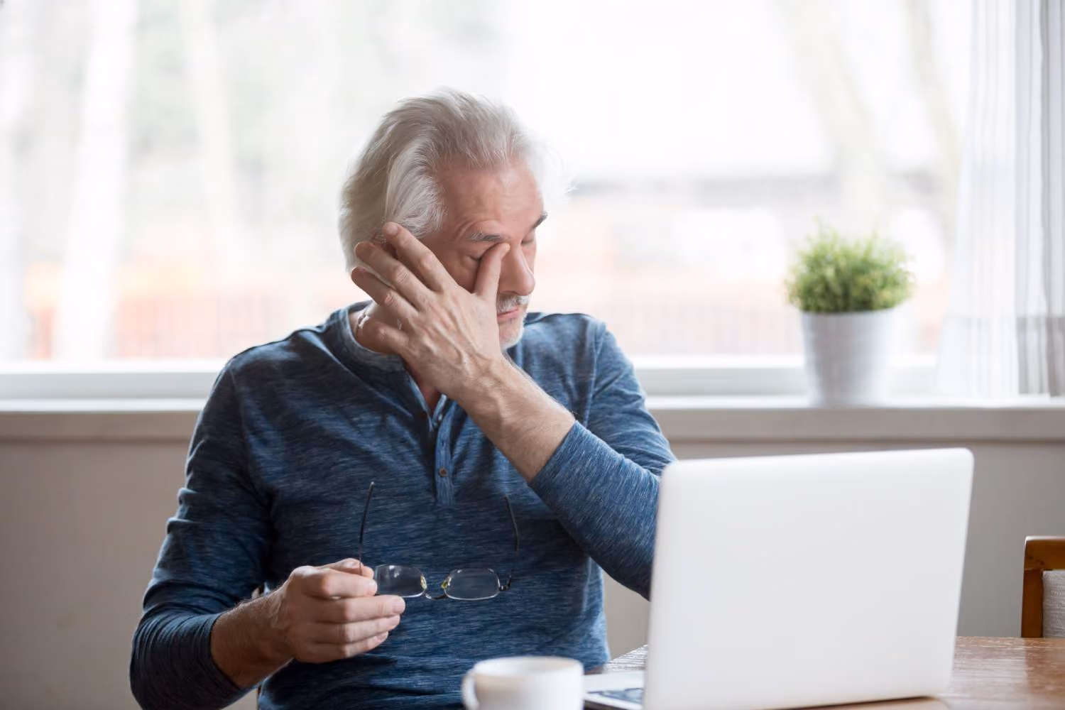 Older adult rubbing his eye due to discomfort