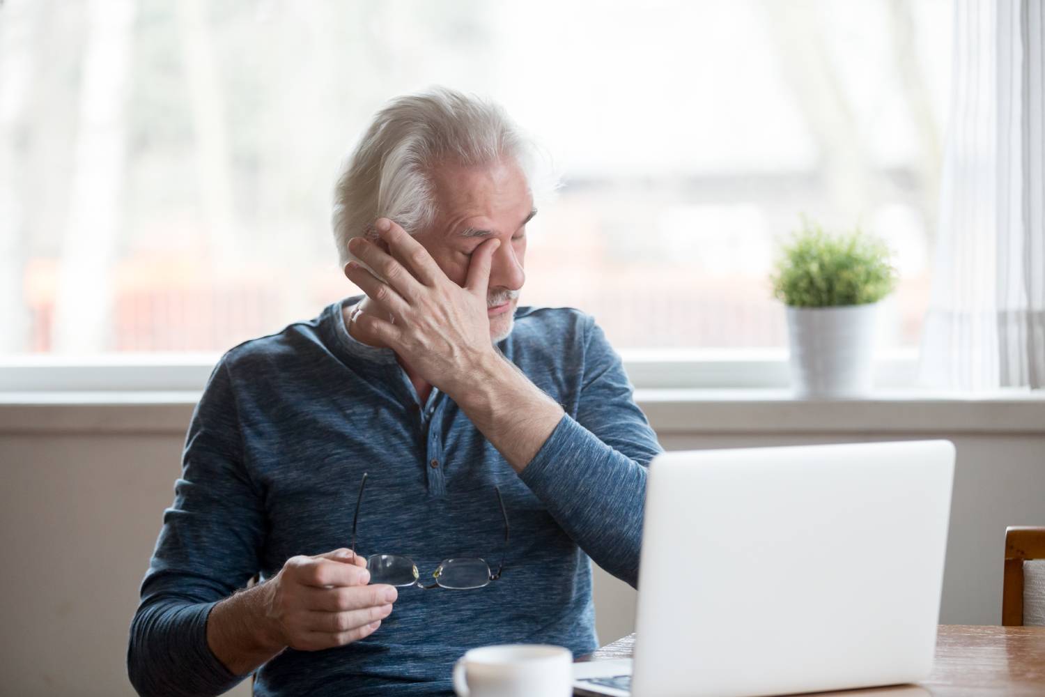 Older adult rubbing his eye due to discomfort