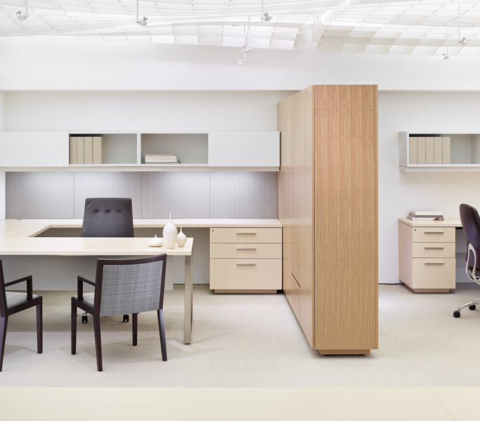 A bright collaborative workspace with custom backpainted glass surfaces and integrated office storage.