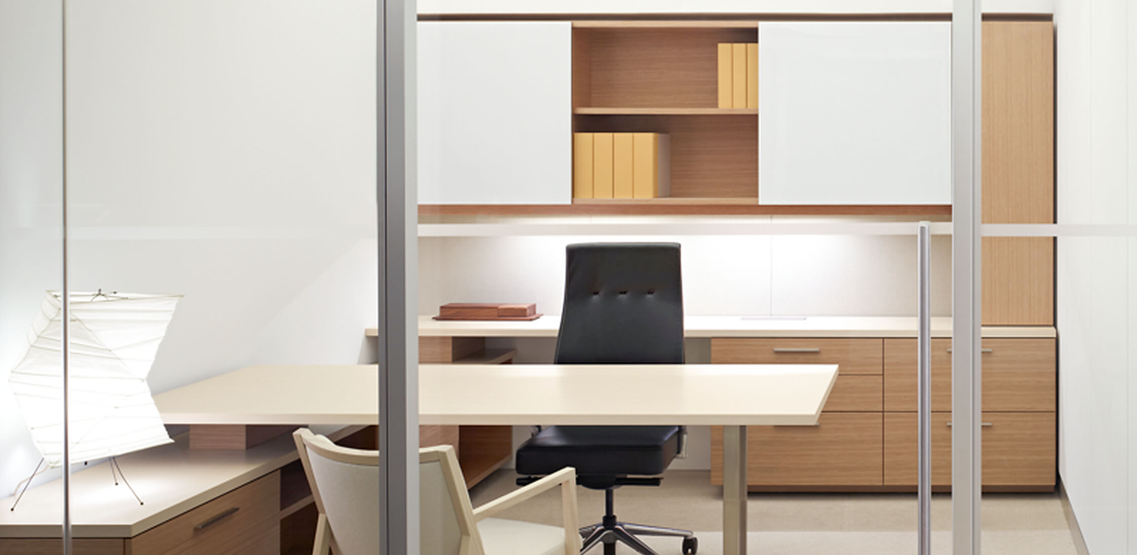 A refined private office integrating backpainted glass surfaces with a coordinated sliding door system.
