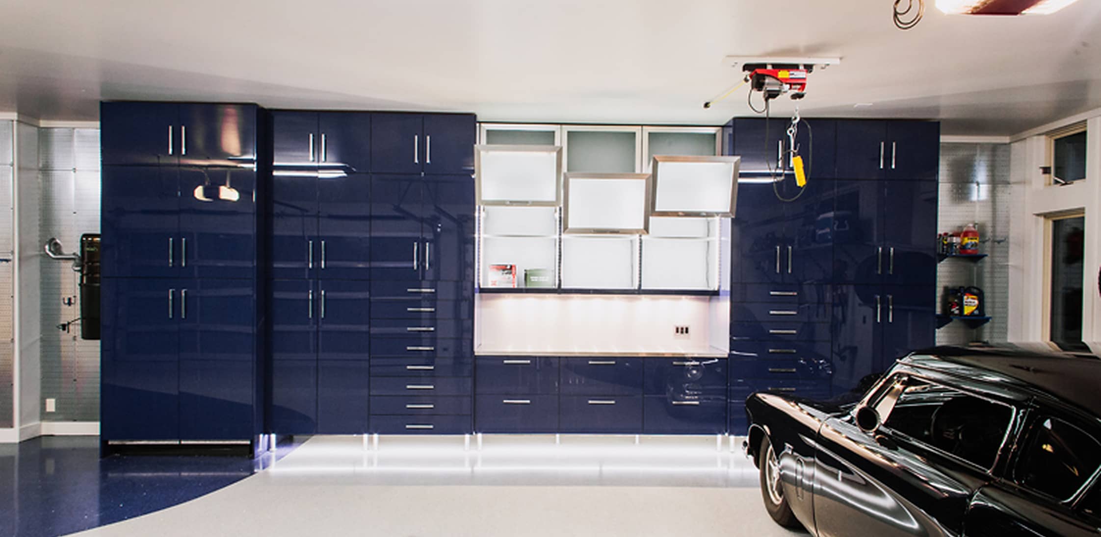 A durable garage storage system combining Cobalt Blue dECOLuxe fronts, AF003 brushed stainless frames and satin glass.