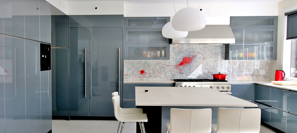 An artistic kitchen featuring custom backpainted glass doors and drawer fronts.