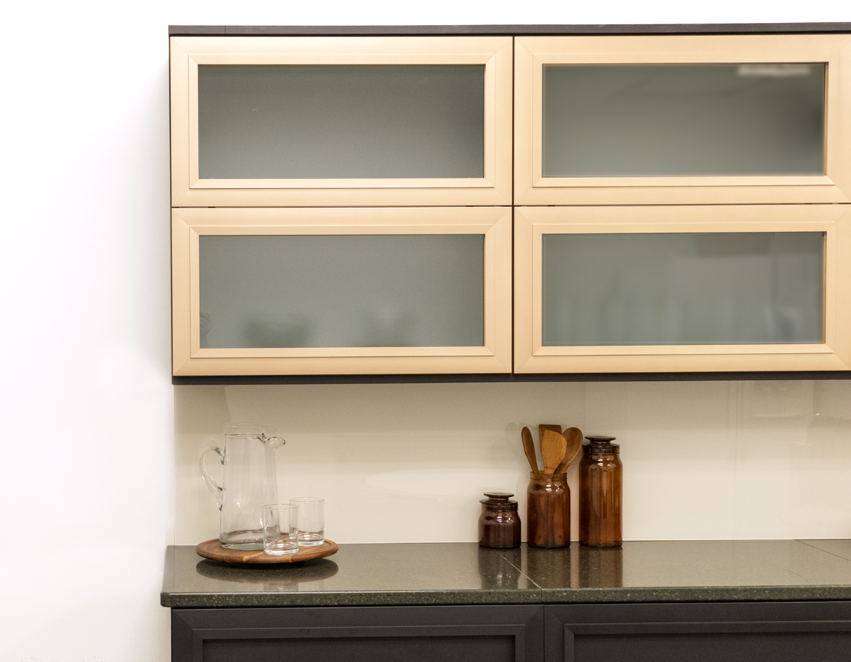 Modern kitchen storage featuring aluminum frame glass upper cabinets, dark lower cabinetry, and a minimalist countertop.
