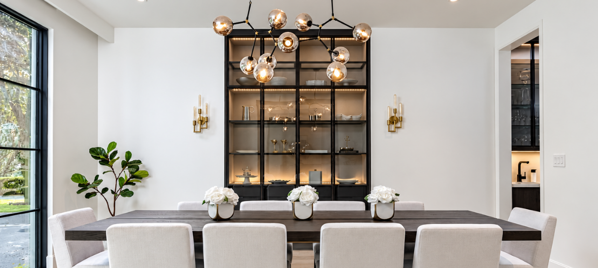 Modern luxury dining room featuring black aluminum frame glass display cabinets with integrated LED lighting, contemporary furnishings, and elegant architectural details.