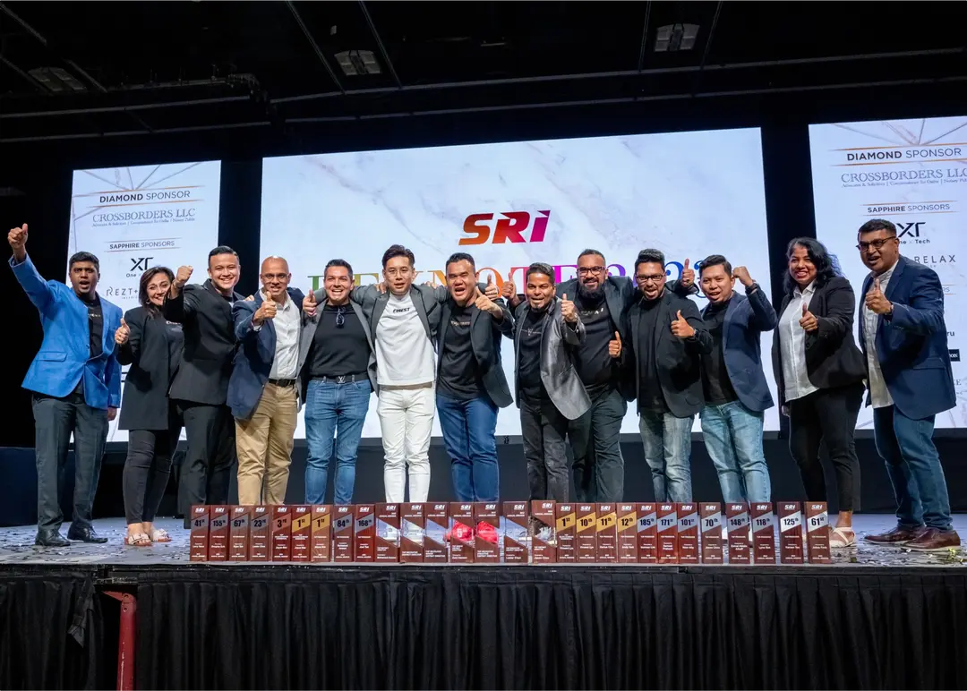 SRI salespeople on stage with their awards
