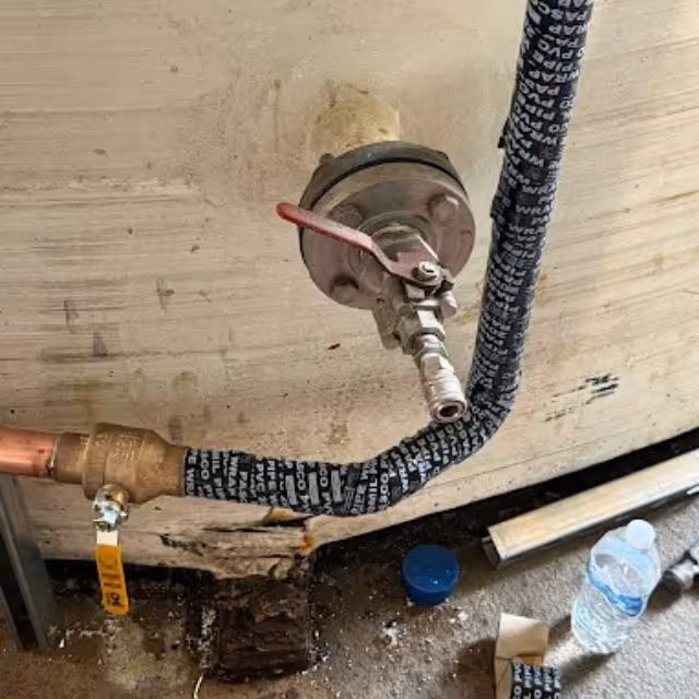 Water heater gas control valve and supply line connection.