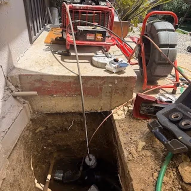 Sewer line inspection camera and equipment set up at an outdoor cleanout access point.