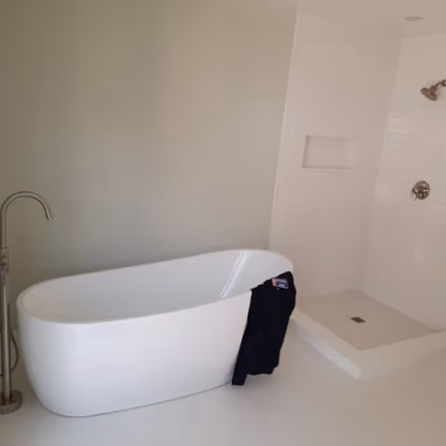 Modern bathroom with freestanding bathtub and walk-in shower installation.