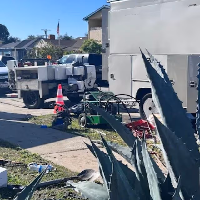 Plumbing service trucks and equipment set up for residential sewer repair.