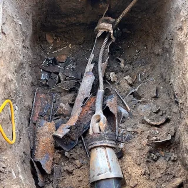 Broken cast iron sewer pipe removed during underground plumbing repair.