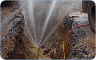 Underground water line leak spraying in trench in Los Angeles, CA.