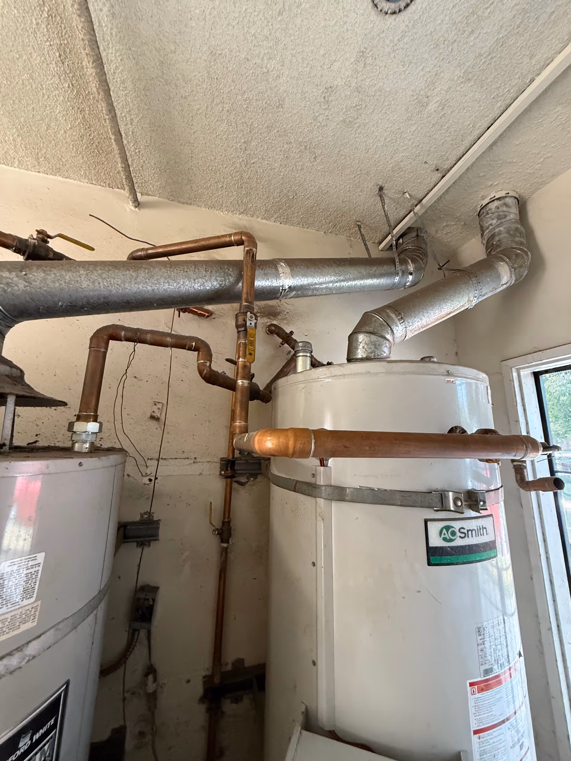 Gas line installation in Los Angeles, CA connecting copper piping to an A.O. Smith water heater.