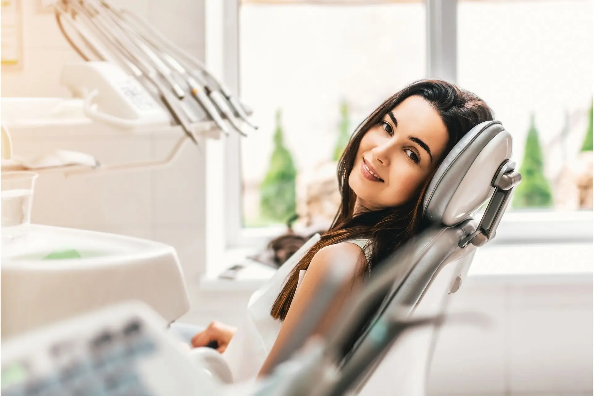 Woman smiling while reclining in a dental chair at a dentist's office.