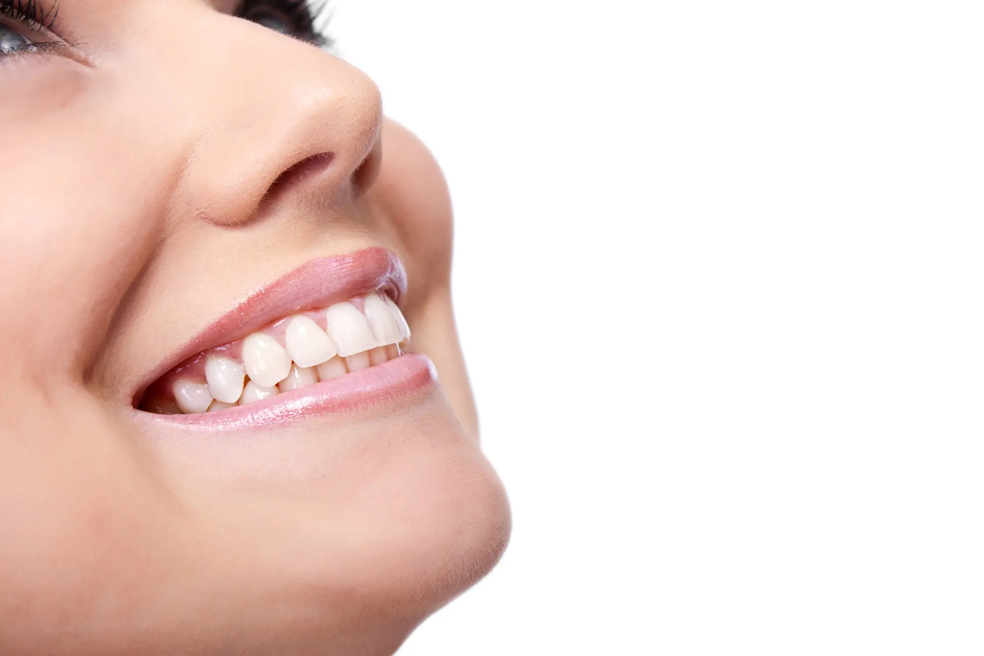 Close-up of a smiling woman showing clean, white teeth and pink lips.