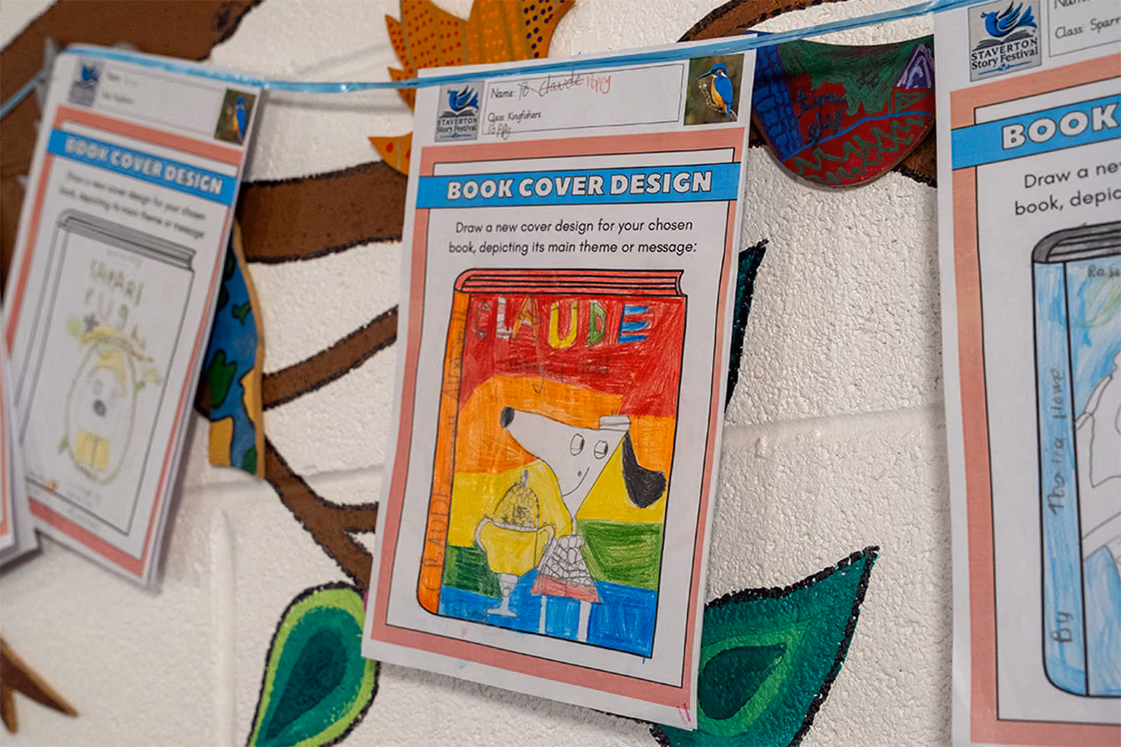 Pupil's illustrated book cover design pinned up as part of Story Festival bunting.