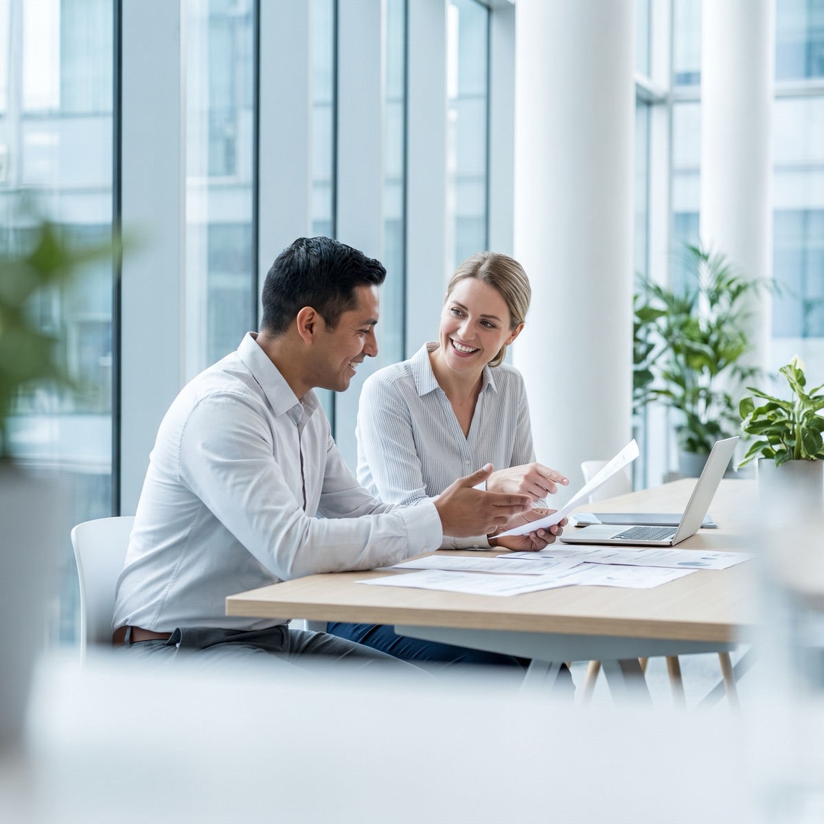 Two colleagues reviewing printed pay and benefits documents